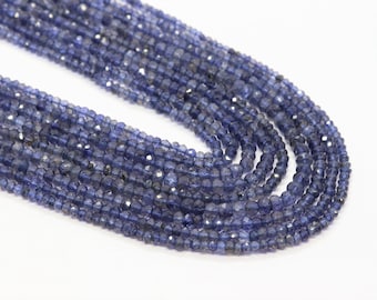 May include: A strand of blue gemstone beads, likely kyanite, with a faceted finish. The beads are round and have a slightly irregular shape. The strand is approximately 16 inches long.