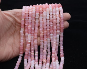 Pode incluir: Um fio de contas de opala rosa, cada conta tem um formato quadrado arredondado pequeno. As contas são enfiadas em um fio transparente e têm aproximadamente 6 mm de tamanho.