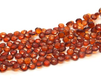 May include: A strand of faceted garnet beads in a warm reddish-brown color. The beads are round and have a smooth, polished finish.