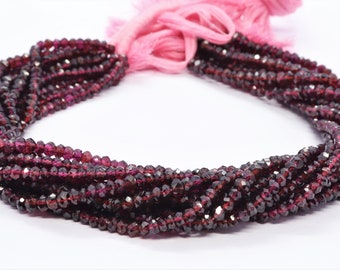 May include: A strand of dark red garnet beads, faceted and strung on a thread. The beads are small and uniform in size, creating a delicate and elegant look.