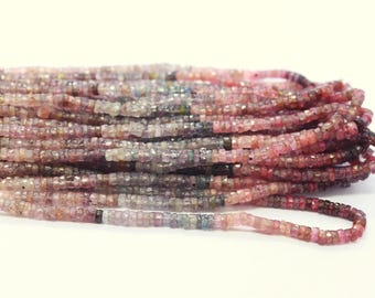 May include: Strands of small, square-cut beads in shades of pink, red, and gray. The beads are strung together, creating a textured and colorful display. The beads are likely gemstones or crystals, suitable for jewelry making.