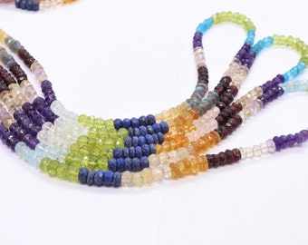 May include: A multi-strand necklace made of various gemstone beads. The beads are arranged in a rainbow pattern, with colors including blue, green, yellow, orange, pink, and purple.