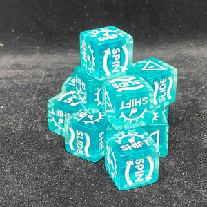 May include: A collection of translucent teal dice with white text and symbols. Each die features the words "SHIFT", "SPIN", and "SLIDE", along with gear and arrow icons. The dice are stacked on a dark surface.