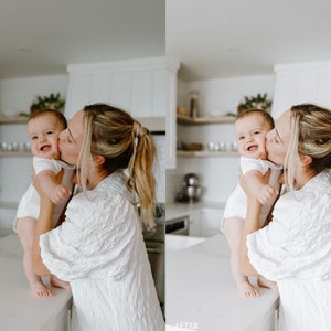 Puede incluir: Una mujer con un vestido blanco sostiene a un beb&eacute; en sus brazos y lo besa en la mejilla. El beb&eacute; lleva un body blanco y tiene una gran sonrisa en su rostro. La mujer y el beb&eacute; est&aacute;n en una cocina con gabinetes blancos y una encimera blanca.