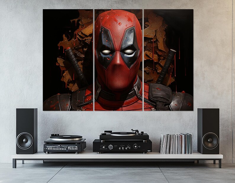 K&ouml;nnte beinhalten: Ein dreiteiliger Leinwanddruck mit Deadpool. Das Kunstwerk zeigt Deadpools rote und schwarze Maske und Kost&uuml;m vor einem dunklen Hintergrund mit Elementen einer Kampfszene. Der Druck befindet sich &uuml;ber einem wei&szlig;en Regal mit Stereoanlage.