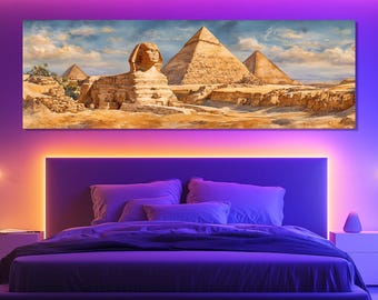 May include: A rectangular canvas print depicting the Sphinx and pyramids of Giza under a cloudy sky. The artwork features warm, earthy tones of tan, brown, and gold, creating a desert landscape scene. The print is mounted above a bed with purple and orange lighting.