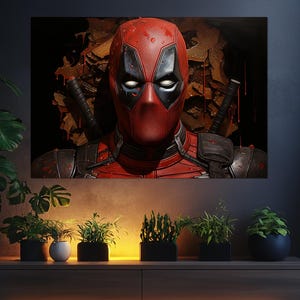 K&ouml;nnte beinhalten: Leinwanddruck mit Nahaufnahme von Deadpool's Gesicht. Der Superheld tr&auml;gt eine rot-schwarze Maske und einen Anzug. Der Hintergrund ist dunkel mit einem strukturierten, braun-schwarzen Design. Zwei Schwerter sind hinter Deadpool zu sehen.