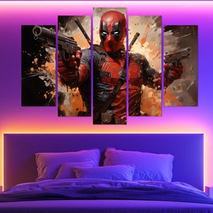 May include: A five-panel canvas print of Deadpool, the Marvel Comics character. The artwork shows Deadpool in his red and black costume, holding two guns. The background features orange and black paint splatter effects.