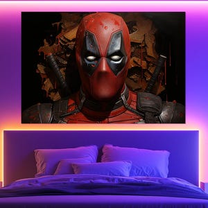 K&ouml;nnte beinhalten: Ein gro&szlig;er Leinwanddruck von Deadpool, der Marvel Comics-Figur, h&auml;ngt &uuml;ber einem Bett. Das Kunstwerk zeigt Deadpools rote und schwarze Maske und Kost&uuml;m vor einem dunklen Hintergrund. Der Raum wird durch violette und orangefarbene Akzentbeleuchtung beleuchtet.