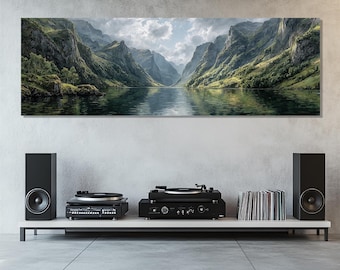 May include: Panoramic canvas print of a mountain lake scene. The artwork depicts a serene landscape with towering green mountains reflected in the calm water. Below, a white shelf holds two turntables, speakers, and a stack of vinyl records.