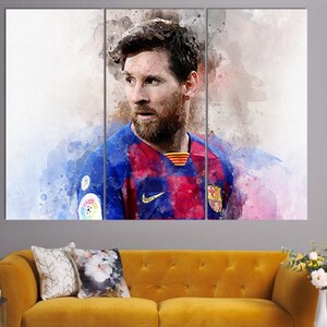 May include: A watercolor painting of a soccer player wearing a blue and red jersey with a white Nike swoosh logo. The player has a beard and is looking to the left. The background is a watercolor wash of blue, pink, and white.