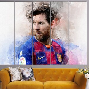 May include: A watercolor painting of a soccer player wearing a blue and red jersey with a white Nike swoosh logo. The player has a beard and is looking to the side. The background is a blurred watercolor wash of pink and blue.