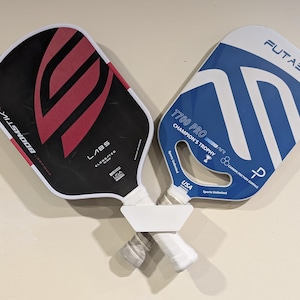 Soporte de pared para colgar paletas de pickleball cruzadas