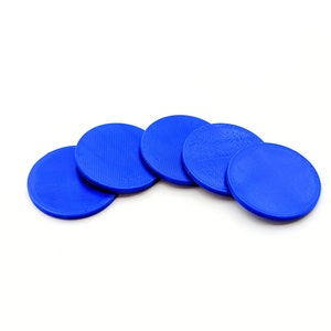 Op de afbeelding: Vijf blauwe plastic schijven, gerangschikt in een halve cirkel, met een getextureerd oppervlak.