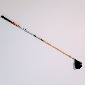 May include: A golf club with an orange and black shaft and a black club head.