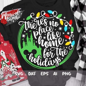 May include: A black t-shirt with a green circle design featuring a Mickey Mouse head, a silhouette of Cinderella's castle, and the text "There's no place like home for the holidays" surrounded by a string of colorful Christmas lights.