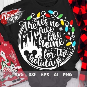 May include: A black t-shirt with a white circle design featuring a Mickey Mouse head, a silhouette of Cinderella's castle, and the text "there's no place like home for the holidays" surrounded by a string of colorful Christmas lights.