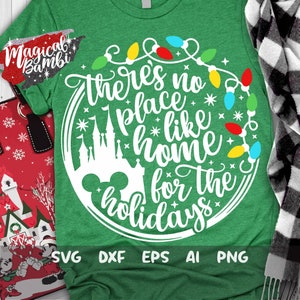 May include: Green t-shirt with a white design that says "There's no place like home for the holidays". The design also includes a silhouette of Cinderella's castle and Mickey Mouse ears. The design is surrounded by a string of colorful Christmas lights.