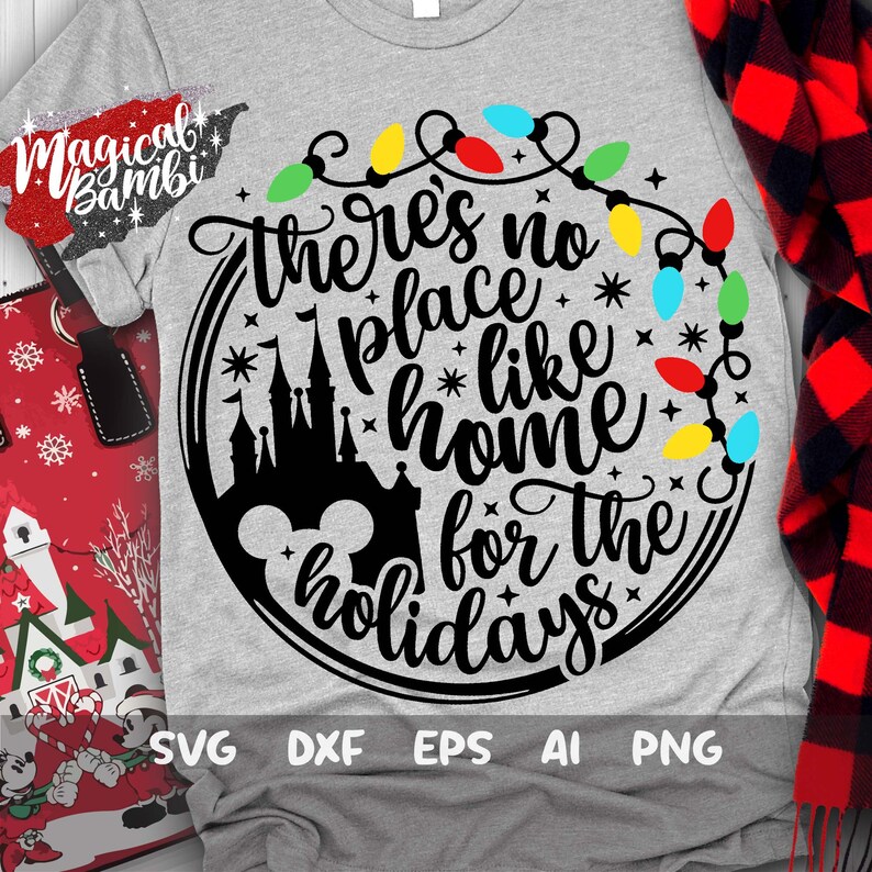 May include: A gray t-shirt with a black circle design featuring a silhouette of Cinderella's castle, Mickey Mouse ears, and the text "there's no place like home for the holidays" surrounded by a string of colorful Christmas lights.