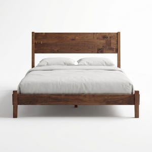 May include: A wooden bed frame with a headboard. The bed frame and headboard are made of dark brown wood. The bed is made up with white sheets and pillows.