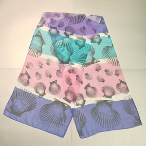 Könnte beinhalten: Ein lila, blauer und rosa gemusterter Seidenschal mit einem Design aus Muscheln. Der Schal ist aus einem durchsichtigen Stoff gefertigt und hat ein zartes Gefühl.