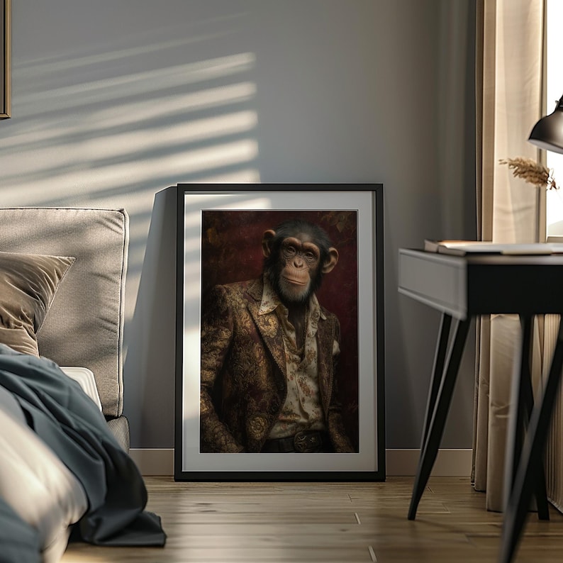 May include: Framed artwork featuring a chimpanzee in a patterned suit and open shirt. The portrait has a dark red background and is displayed in a black frame. The image is set against a gray wall with sunlight streaming through a window.