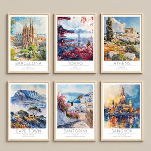 Può includere: Un set di sei stampe artistiche ad acquerello incorniciate che raffigurano monumenti globali tra cui Barcellona, Tokyo, Atene, Città del Capo, Santorini e Bangkok. Ogni stampa presenta il nome della città, il paese e un testo descrittivo.
