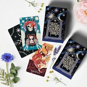 Op de afbeelding: Een verzameling tarotkaarten met illustraties van een skelet, een vrouw die op een tijger rijdt en hemelse ontwerpen. De kaartspellen zijn gelabeld met "Four Courts Tarot". De kaarten zijn gerangschikt met bloemen en bladeren.