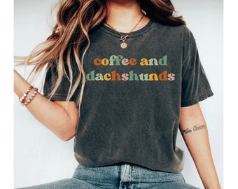 May include: A dark gray t-shirt with the text "coffee and dachshunds" in colorful letters. The letters are in a retro style font.