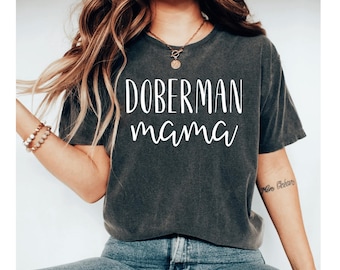 May include: A dark grey t-shirt with the text "Doberman mama" printed in white on the front.
