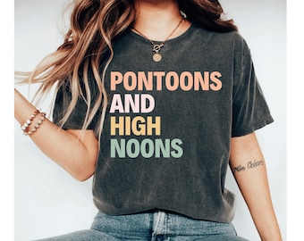 May include: A dark gray t-shirt with the text "PONTOONS AND HIGH NOONS" printed in colorful letters. The text is stacked vertically with the word "PONTOONS" in pink, "AND" in light blue, "HIGH" in yellow, and "NOONS" in green.