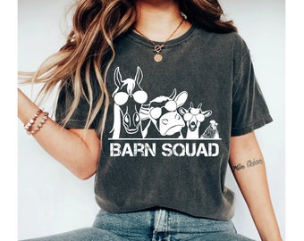 May include: A dark gray t-shirt with a white graphic of a horse, cow, goat, and chicken wearing sunglasses. The text "Barn Squad" is printed below the animals.