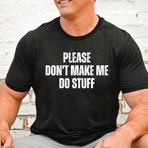 May include: Black crew neck t-shirt with the white text "PLEASE DON'T MAKE ME DO STUFF". The shirt is made of a soft material and is suitable for casual wear. The text is centered on the front of the shirt.