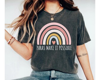 May include: A dark gray t-shirt with a rainbow graphic and the text "Paras Make It Possible".