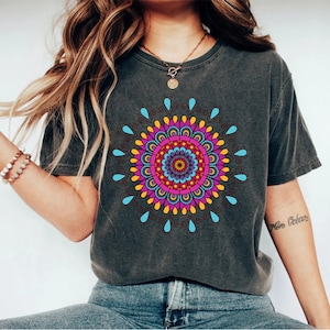 May include: A dark gray t-shirt with a colorful mandala design printed on the front. The mandala features a variety of colors, including pink, blue, yellow, and orange.