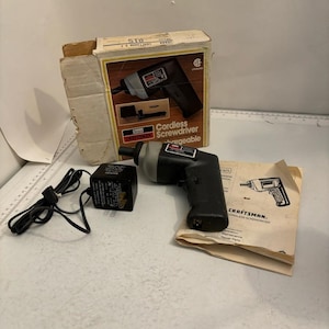 Puede incluir: Un destornillador inalámbrico Craftsman negro y gris con un adaptador de corriente negro, una caja de cartón con imágenes y texto del producto, y un manual de instrucciones. La caja muestra el texto Sears Craftsman Cordless Screwdriver Rechargeable.