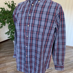 May include: A long-sleeved button-down shirt with a blue, red and white plaid pattern.