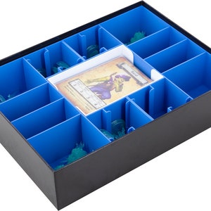 Può includere: Una scatola organizzatrice nera con scomparti blu per riporre pezzi di gioco e carte. La scatola ha un inserto bianco con la parola "Round" stampata su di esso.