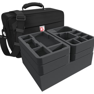 Könnte beinhalten: Eine schwarze gepolsterte Tragetasche mit einem Schultergurt und einem Stapel von vier grauen Schaumstoffeinsätzen mit Fächern zur Organisation von Spielteilen.