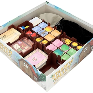 Peut inclure: Une boîte en carton marron avec un couvercle blanc, contenant un organisateur de jeu pour le jeu de société Stardew Valley. L'organisateur comporte des compartiments pour les cartes, les jetons et les autres composants du jeu. La boîte est décorée d'une image de dessin animé d'une ferme et d'un champ vert.