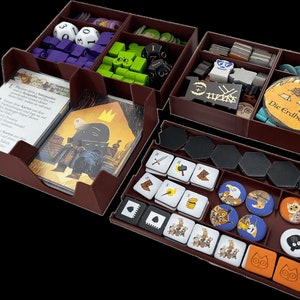 May include: A brown wooden game organiser with multiple compartments for storing game pieces and cards. The organiser has compartments for dice, tokens, cards, and other game components. The organiser is labelled with the text "Die Erdhöhle".