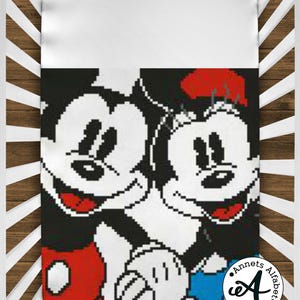 May include: A white crib sheet with a black and white pixelated image of Mickey Mouse and Minnie Mouse. Mickey Mouse is wearing red shorts and Minnie Mouse is wearing a blue dress. The image is surrounded by a white border.