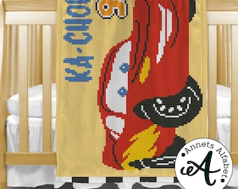 May include: A yellow and red crochet blanket with a cartoon image of a red race car and the text "Ka-Chow!" in blue. The blanket has a black and white checkered border.