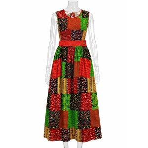 May include: A sleeveless midi dress featuring a vibrant patchwork design with various floral and geometric patterns in shades of red, green, yellow, and black. The dress includes a fitted waistband and a round neckline with a tie closure.