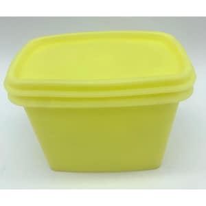 Può includere: Un contenitore giallo per alimenti di forma quadrata con coperchio abbinato. Il contenitore ha un design leggermente affusolato, più largo nella parte superiore e più stretto alla base. Il coperchio si adatta perfettamente, creando una tenuta ermetica.