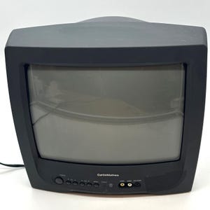 May include: A black Curtis Mathes cathode ray tube television with a curved screen. The front panel features a power button, volume and menu controls, a yellow video input, a white audio input, a headphone jack, and a small speaker grille.