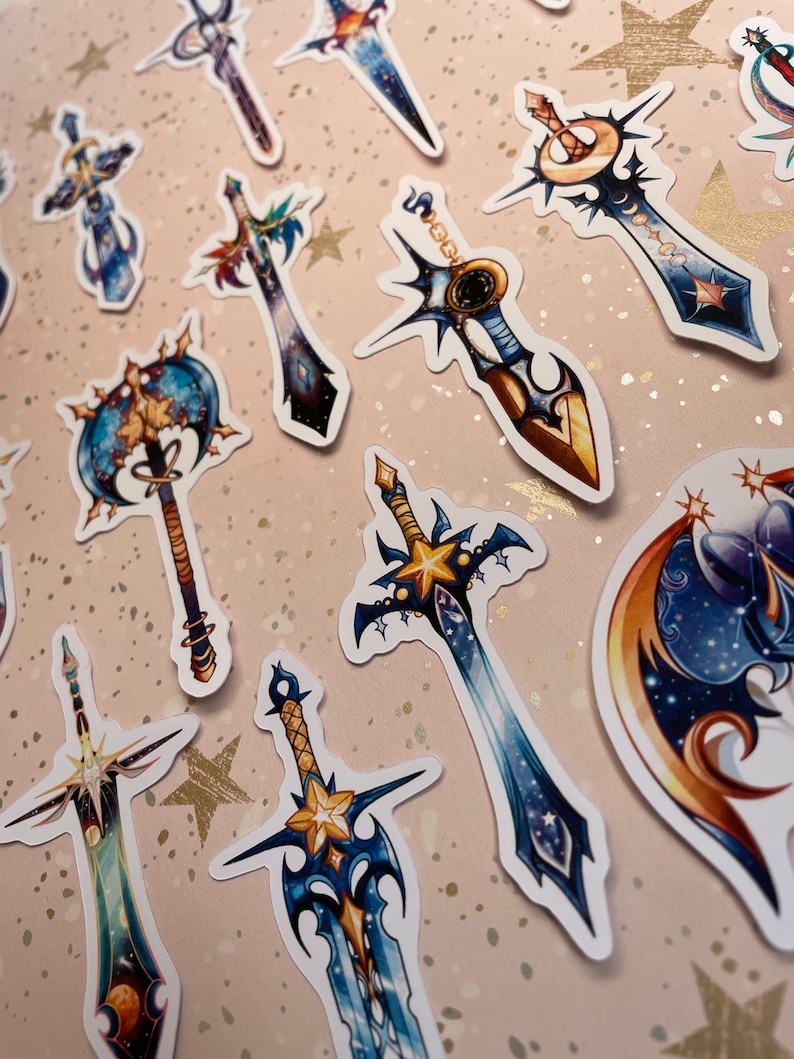 May include: A set of 10 colourful stickers featuring various sword designs with a celestial theme. The swords are decorated with stars, moons, and galaxies. The stickers are perfect for adding a touch of fantasy to your planner, laptop, or water bottle.