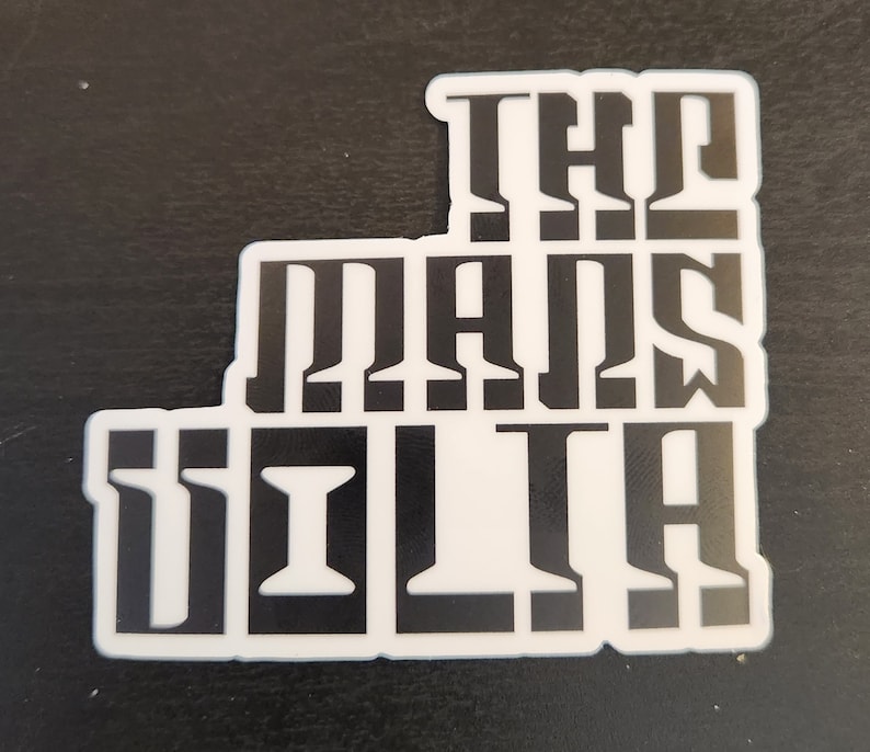 May include: Black and white sticker with the text "The Man's Villa" in a stylised font.