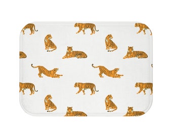 May include: White bath mat with a repeating pattern of orange tigers in various poses.