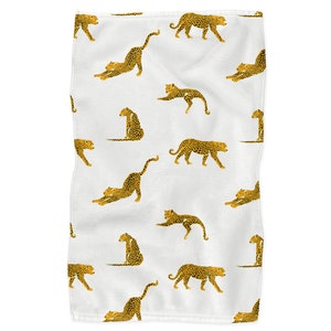 May include: White fabric with a repeating pattern of gold leopard print. The leopards are in various poses, including sitting, standing, and stretching.